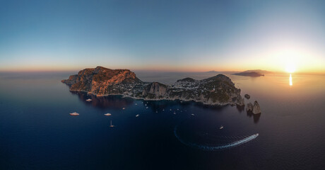 Aerial view of Capri Island at sunset, view of the Faraglioni rock formation along the coastline, Capri, Naples, Campania, Italy.