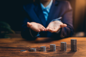 Businessman Showing Hands with Stacks of Coins on a Table Indicating Financial Growth and Investment Strategy