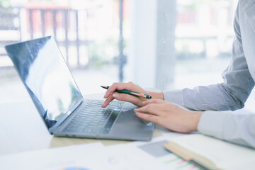 Beautiful looking Asian businesswoman working with digital laptop in office. Businesswoman and marketing concept.