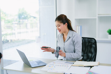 Business people working together analyzing financial charts and business graphs using calculator during a meeting in the office