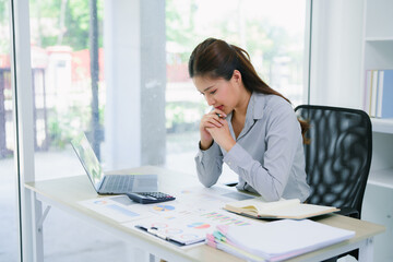 Pain, headache and stressed finance manager feeling sick, tired and worried about a financial problem at her startup company. Young and frustrated professional businesswoman working at an office
