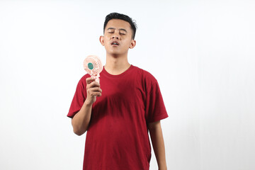 Asian man holding mini portable fan isolated on white background