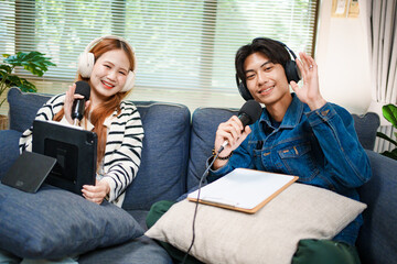 Friendly podcast hosts waving at camera with microphones and headphones