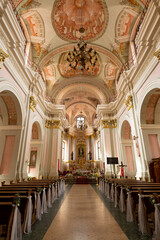 Obraz premium A large church with a long aisle of pews and a large altar. The pews are empty and the altar is covered in flowers