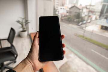 A close-up of a hand holding a sleek smartphone, symbolizing connectivity, modern technology, and digital communication in everyday life.

