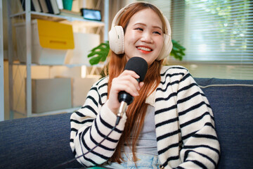 Young woman podcast host smiling with microphone and headphones at home