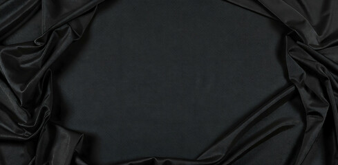 Dark elegant black silk satin fabic surface background with space for design