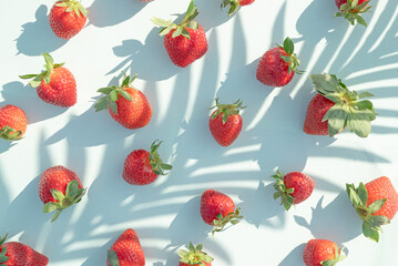 Pattern with natural strawberries on a green background. Summer food concept.