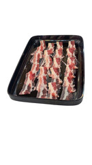 Fresh Bacon Strips on Black Tray Ready for Cooking or Grilling