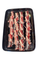 Freshly Sliced Raw Bacon Strips Arrangement on Black Tray