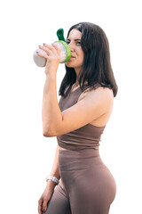 Athletic young woman in sportswear drinking protein cocktail from a shaker, isolated on white background