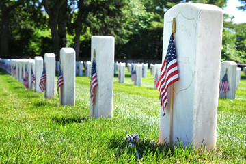 Unknown Soldier tombstone in a Veterans Cemetery decorated with American Flags
