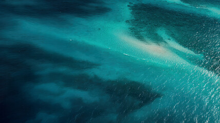 Obraz premium Aerial view of tropical turquoise sea with coral reef shadows and shimmering light on ocean surface