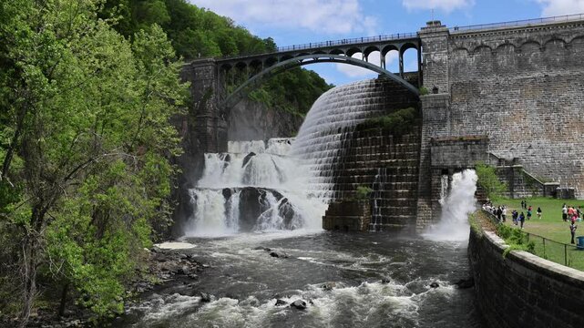 water cascading down waterfall at croton dam (man made and natural drinking water reservoir) westchester new york landmark with old bridge (tourism travel hiking destination) nature landscape