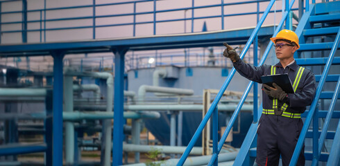 Petrochemical engineer working at petroleum oil refinery industry area. Industrial technician worker maintenance inspect manufacturing energy power gas system at factory.