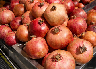 Fresh pomegranates stacked in a market display showcasing vibrant colors and textures of fruit