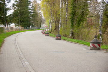 Large round concrete blocks line the roadside as barriers to prevent illegal truck parking and...