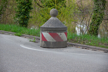 Large round concrete blocks line the roadside as barriers to prevent illegal truck parking and...