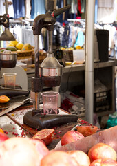 Pomegranate juice press machine with fresh fruit in vibrant market setting showcasing local produce