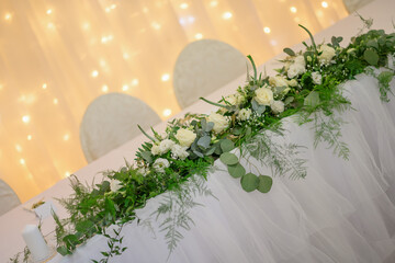wedding table with exclusive floral arrangement prepared for reception, wedding or event centerpiece in greenery style