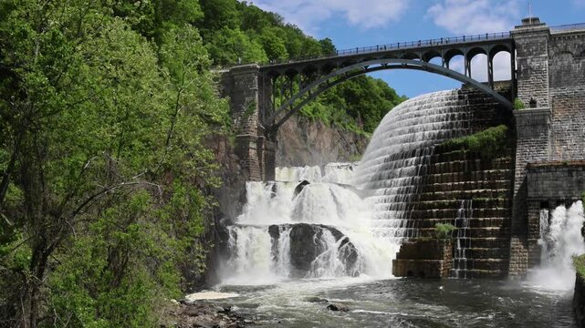 water cascading down waterfall at croton dam (man made and natural drinking water reservoir) westchester new york landmark with old bridge (tourism travel hiking destination) nature landscape
