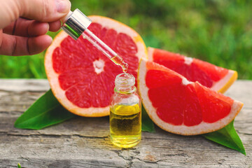 grapefruit essential oil in a bottle. Selective focus.