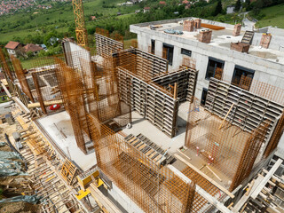 Construction site view showcasing rebar structures and concrete forming indicating active building...