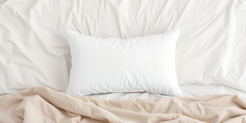Obraz premium A top view of a white pillow on a white bed with a beige blanket in a bright and airy setting
