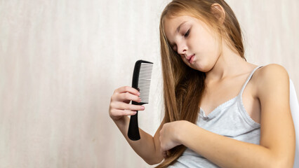 8 years old girl brushing her long hair in her room in the morning