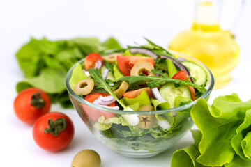 Healthy salad from fresh vegetables, greens, arugula and olives. Selective focus.