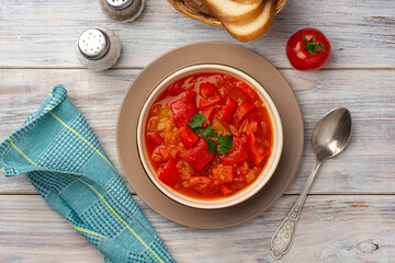 Traditional Hungarian dish lecho or Lecso or Letscho. Stew with peppers, tomatoes and onions in bowl on wooden background.