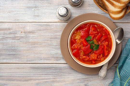 Traditional Hungarian dish lecho or Lecso or Letscho. Stew with peppers, tomatoes and onions in bowl on wooden background.