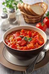 Traditional Hungarian dish lecho or Lecso or Letscho. Stew with peppers, tomatoes and onions in bowl on wooden background.