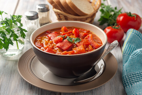 Traditional Hungarian dish lecho or Lecso or Letscho. Stew with peppers, tomatoes and onions in bowl on wooden background.