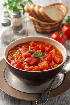 Traditional Hungarian dish lecho or Lecso or Letscho. Stew with peppers, tomatoes and onions in bowl on wooden background.