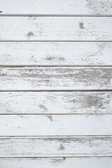 Peeling paint on weathered white planks provides a textured and rustic surface for backgrounds...