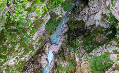 Aerial view of a stunning turquoise river flowing through a rugged moss covered canyon A scenic nature shot