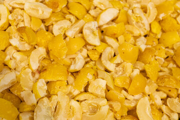 A close-up image showing chopped frozen quinces in various sizes, highlighting their yellow color and icy texture, ideal for culinary use.