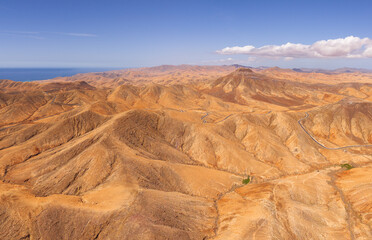 Naklejka premium Dramatic aerial panoramic image of Montana Cardon, the Jandia peninsular and the volcanic mountain landscape of Fuerteventura Canary Islands Spain