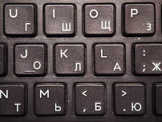 Keyboard closeup displaying cyrillic and latin characters, revealing multilingual typing functionality and international communication context