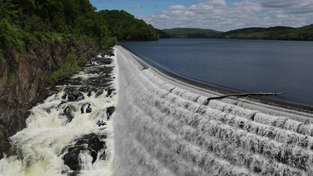 water cascading down waterfall at croton dam (man made and natural drinking water reservoir) westchester new york landmark with old bridge (tourism travel hiking destination) nature landscape