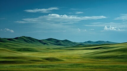  Green field surrounded by mountains and blue sky with white clouds in backdrop
