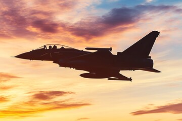 A fighter jet silhouetted against a colorful sunset sky, creating a dramatic scene