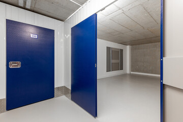 Modern self-storage facility corridor with blue doors