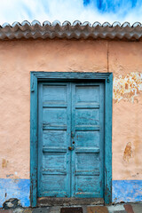 Alte und verwitterte Eingangstür aus Holz an einem mediterranen Wohnhaus auf der spanischen Insel La Palma