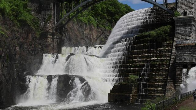 water cascading down waterfall at croton dam (man made and natural drinking water reservoir) westchester new york landmark with old bridge (tourism travel hiking destination) nature landscape