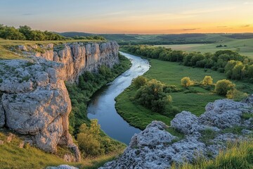 Scenic view of a river winding through a lush valley surrounded by cliffs at golden hour.