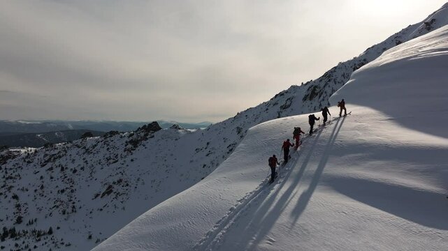 Adventurers climbing snowy mountain ridge in scenic winter landscape