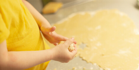 A childs small hands joyfully working with soft dough on a clean countertop, showcasing the fun and excitement of baking