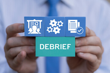 Business Debriefing concept. Business person holding colored blocks sees text: DEBRIEF. Debrief.